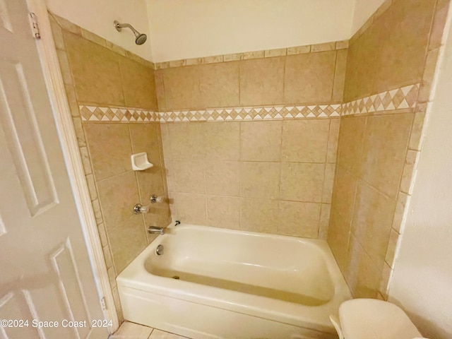 bathroom with tiled shower / bath, tile patterned flooring, and toilet