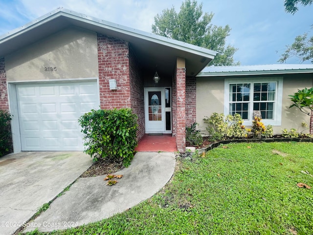 ranch-style home with a garage and a front lawn