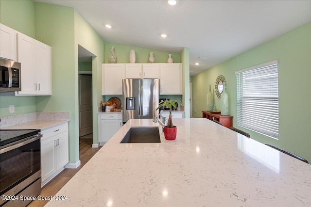 1447 Colebrook Cir SW, Palm Bay, FL 32908 - kitchen with appliances with stainless steel finishes, white cabinets, a sink, light stone countertops, and recessed lighting