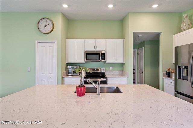 1447 Colebrook Cir SW, Palm Bay, FL 32908 - kitchen featuring stainless steel appliances, light stone counters, white cabinets, recessed lighting, and a sink