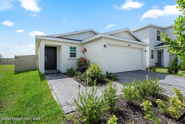 1447 Colebrook Cir SW, Palm Bay, FL 32908 - view of front of house featuring stucco siding, an attached garage, and decorative driveway