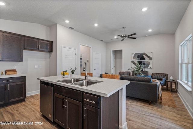 kitchen with sink, light wood-type flooring, vaulted ceiling, stainless steel dishwasher, and a center island with sink