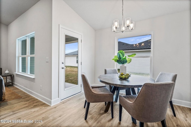 dining space with lofted ceiling, a chandelier, and light hardwood / wood-style floors