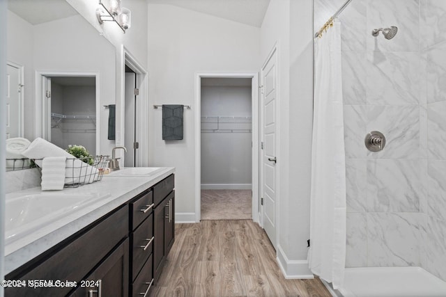 bathroom with vanity, hardwood / wood-style floors, vaulted ceiling, and curtained shower