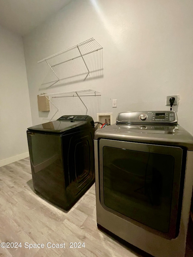 clothes washing area with light hardwood / wood-style floors and separate washer and dryer