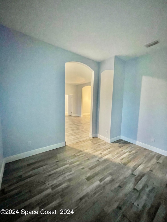 spare room featuring hardwood / wood-style floors and a textured ceiling