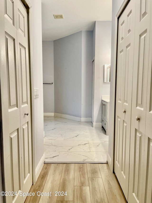 hallway with light hardwood / wood-style floors