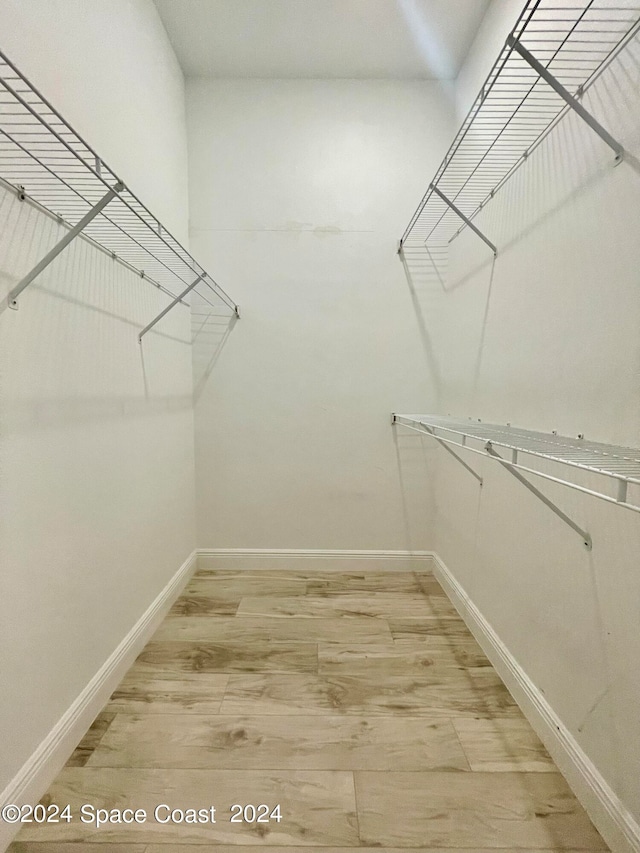 walk in closet with hardwood / wood-style floors