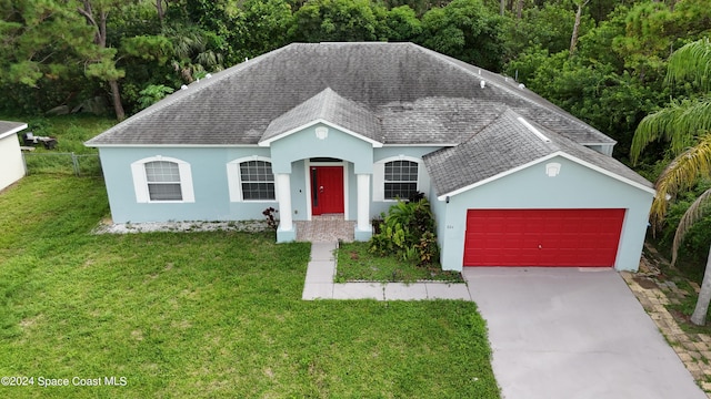 view of front of property featuring a front yard and a garage