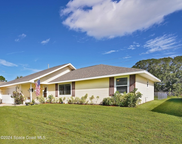 ranch-style house featuring a front yard and a garage