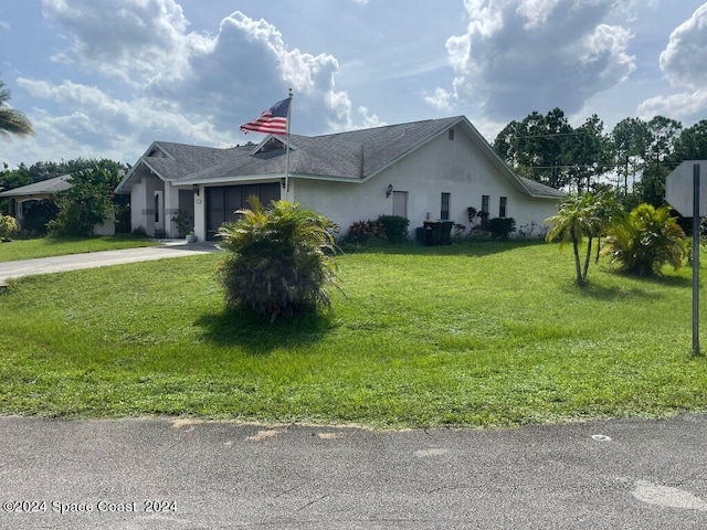 view of front of property with a front yard and a garage