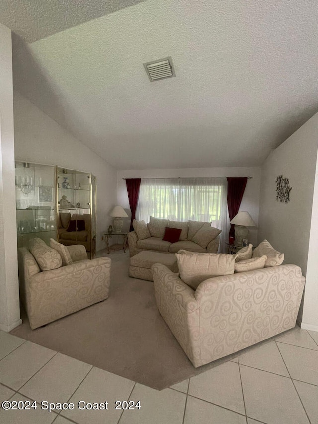 tiled living room with a textured ceiling and vaulted ceiling