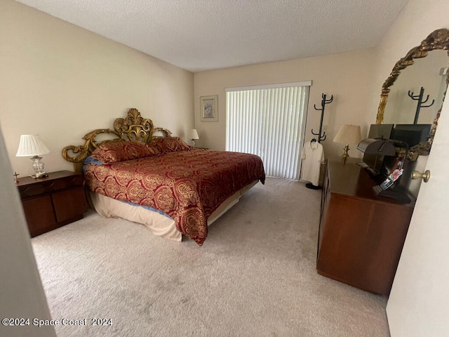 bedroom featuring a textured ceiling and light colored carpet