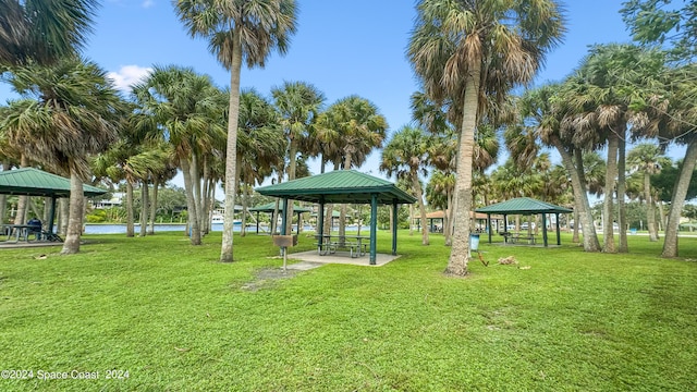 surrounding community with a water view, a gazebo, and a yard