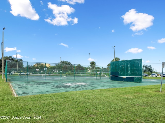 view of tennis court with a lawn