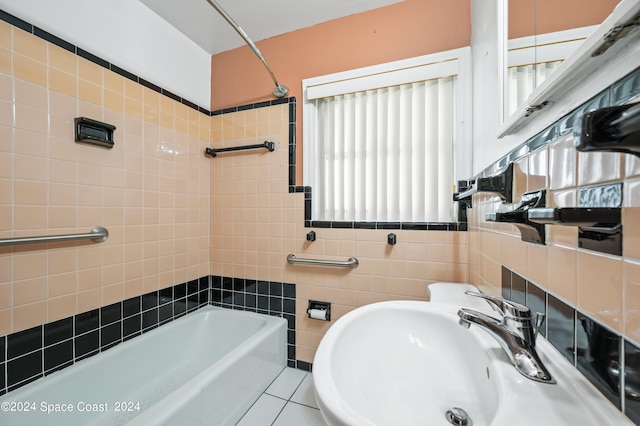 bathroom featuring tiled shower / bath combo, tile patterned flooring, sink, and a wealth of natural light