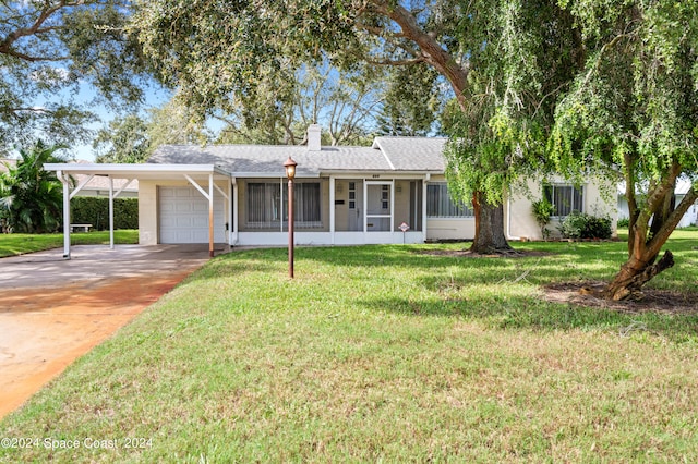 ranch-style house featuring a sunroom, a front lawn, a carport, and a garage