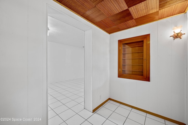 empty room featuring wooden ceiling, wood walls, and light tile patterned floors