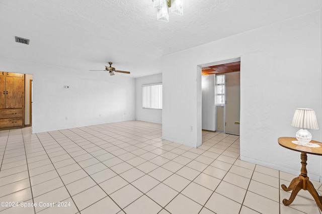 tiled empty room featuring ceiling fan