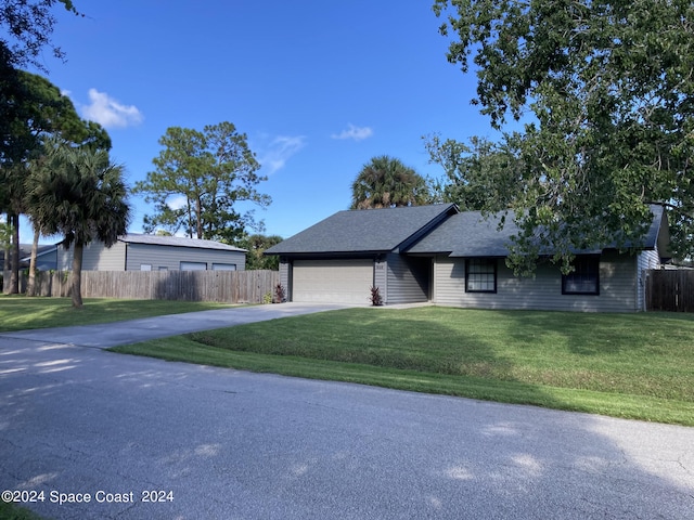 ranch-style house with a garage and a front lawn