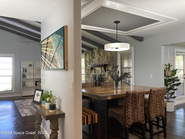 dining area featuring vaulted ceiling with beams, a fireplace, and a healthy amount of sunlight