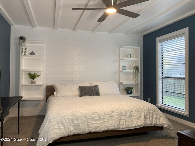 carpeted bedroom with ceiling fan, beamed ceiling, and brick wall