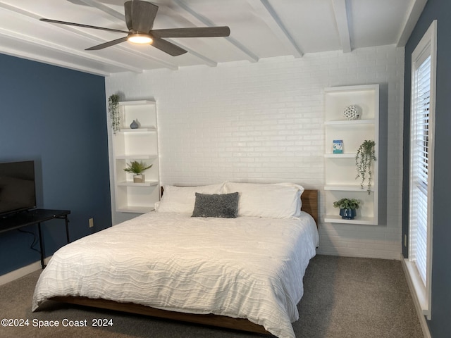 bedroom with carpet, beam ceiling, ceiling fan, and brick wall