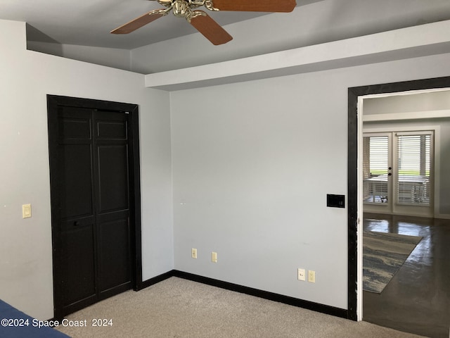 empty room with vaulted ceiling, ceiling fan, and light colored carpet