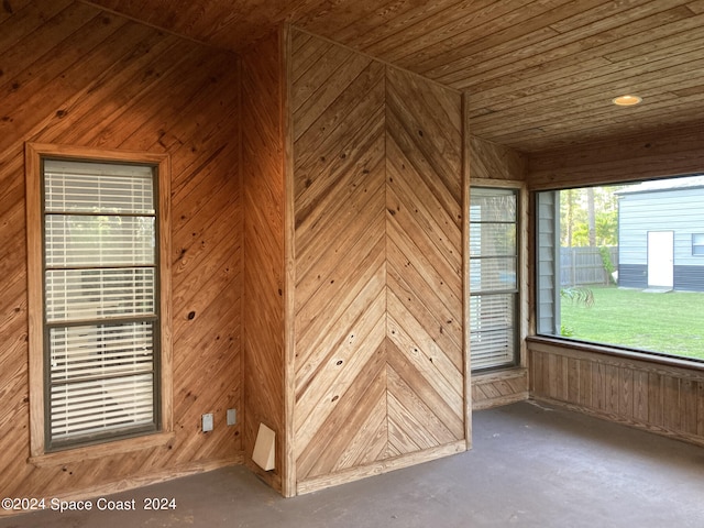 spare room featuring wood walls and wooden ceiling