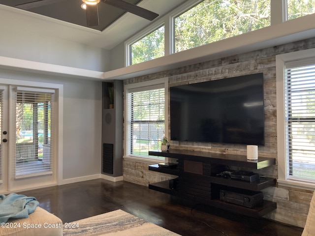 living room with a towering ceiling, ceiling fan, and a healthy amount of sunlight