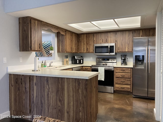 kitchen with stainless steel appliances, kitchen peninsula, and sink