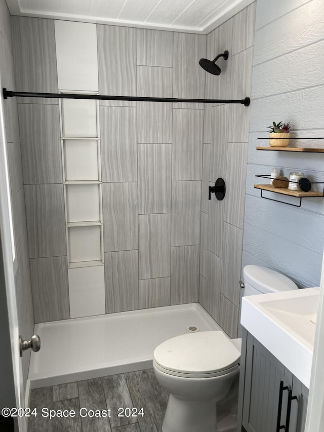 bathroom with vanity, toilet, and tiled shower