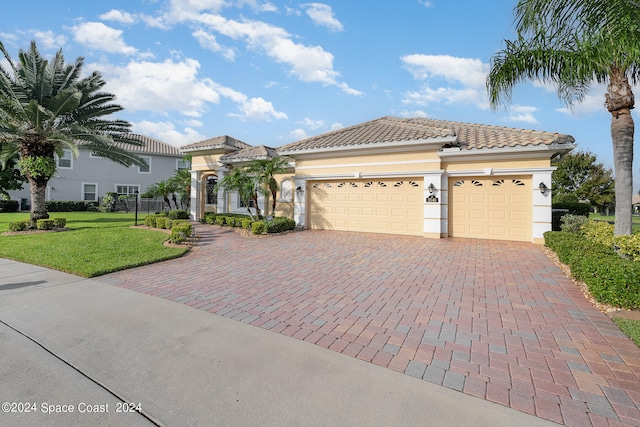 mediterranean / spanish-style home featuring a front lawn and a garage