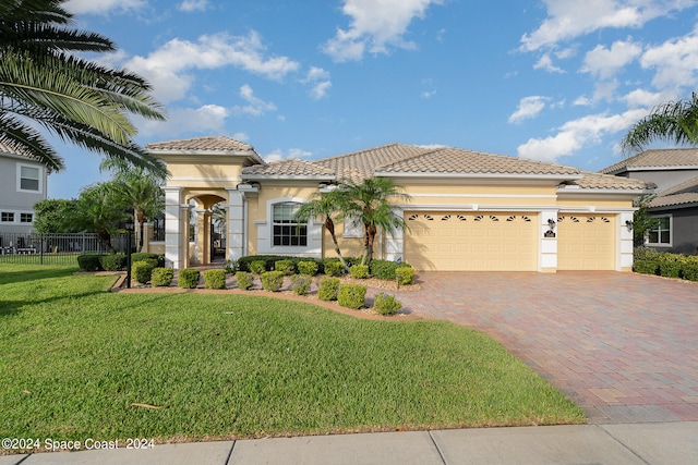 mediterranean / spanish-style home featuring a garage and a front yard