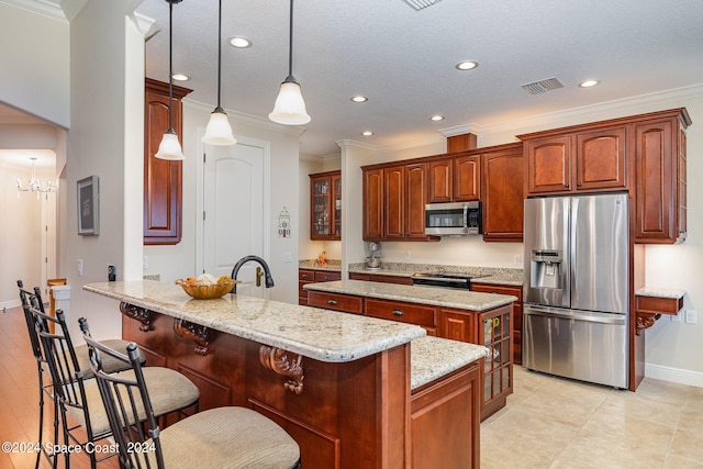 kitchen with a kitchen island with sink, appliances with stainless steel finishes, decorative light fixtures, and crown molding