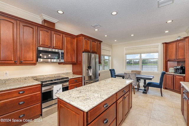 kitchen featuring appliances with stainless steel finishes, light tile patterned flooring, light stone counters, a textured ceiling, and crown molding