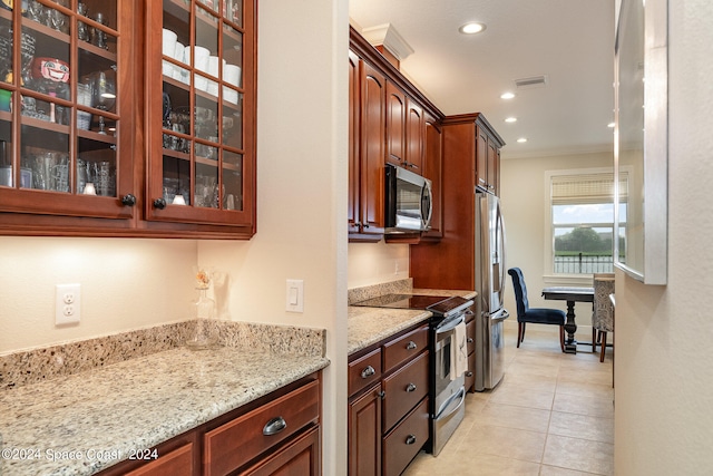 kitchen featuring appliances with stainless steel finishes, ornamental molding, light stone countertops, and light tile patterned floors