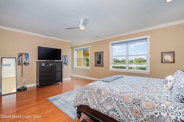 bedroom featuring a textured ceiling, ceiling fan, hardwood / wood-style floors, and crown molding