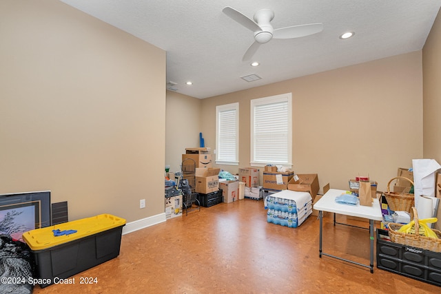 miscellaneous room with ceiling fan and a textured ceiling