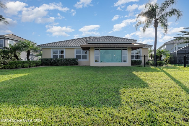 back of property featuring a lawn