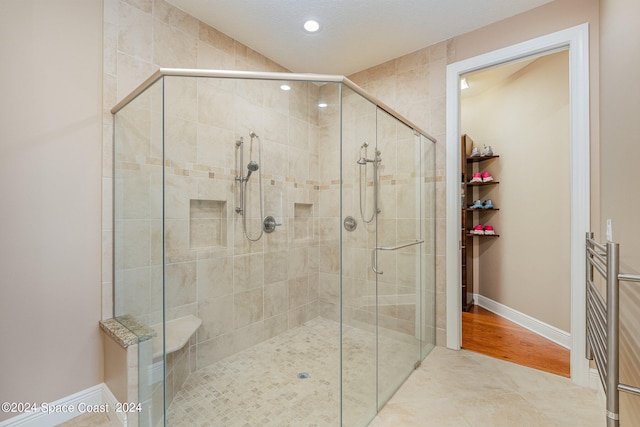 bathroom featuring walk in shower, a textured ceiling, and hardwood / wood-style floors