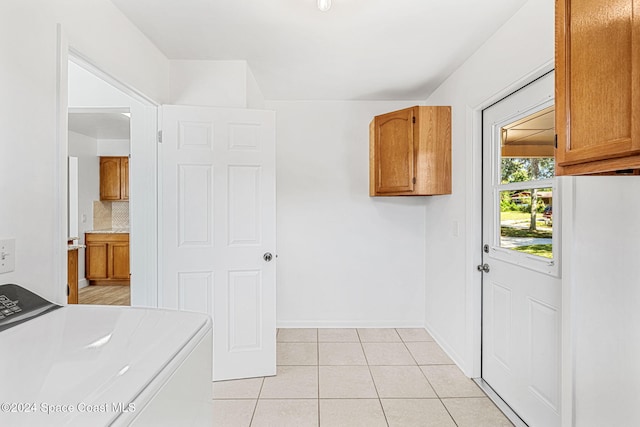 2415 Stanford Dr, Cocoa, FL 32926 - washroom featuring cabinet space, light tile patterned floors, baseboards, and washing machine and clothes dryer