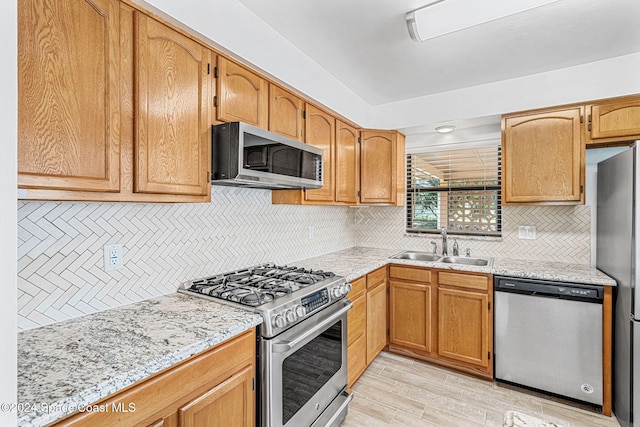 2415 Stanford Dr, Cocoa, FL 32926 - kitchen with stainless steel appliances, backsplash, a sink, and light wood finished floors