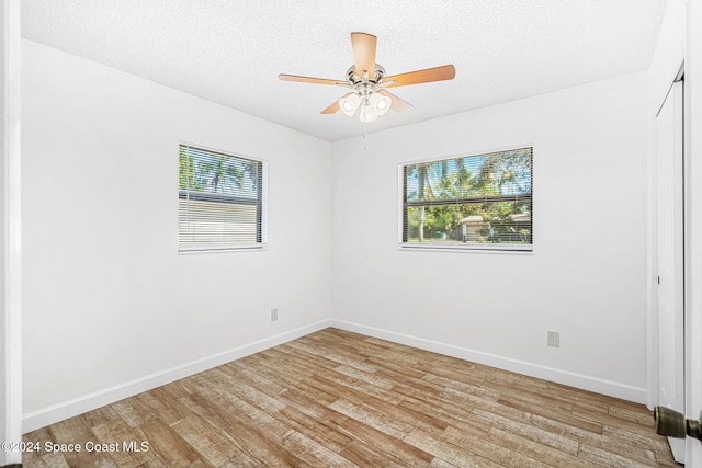 spare room featuring a textured ceiling, light hardwood / wood-style floors, and ceiling fan