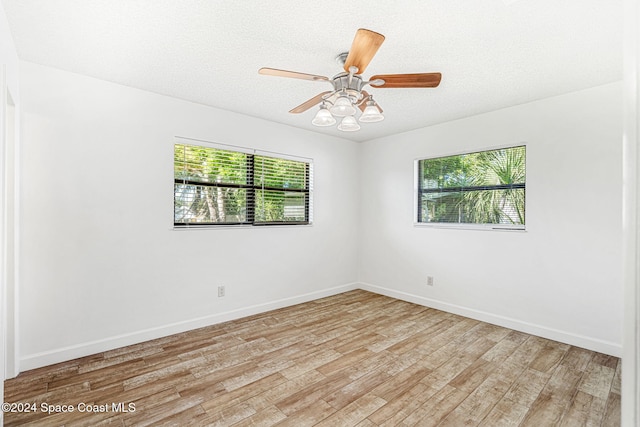 2415 Stanford Dr, Cocoa, FL 32926 - empty room featuring light wood-style floors, baseboards, ceiling fan, and a textured ceiling