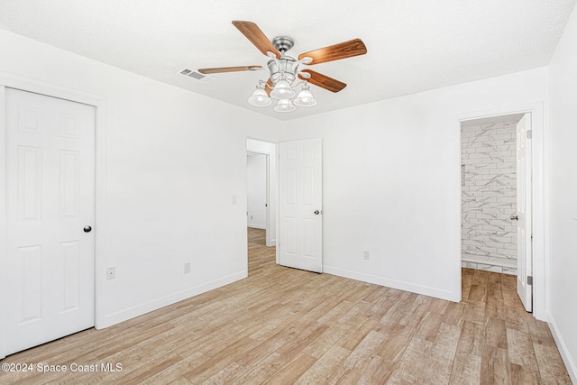 2415 Stanford Dr, Cocoa, FL 32926 - unfurnished bedroom featuring light wood finished floors, baseboards, ensuite bathroom, and ceiling fan