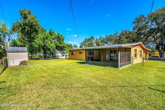 rear view of house with a yard and a sunroom