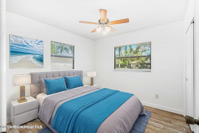 2415 Stanford Dr, Cocoa, FL 32926 - bedroom with wood finished floors, a textured ceiling, baseboards, and ceiling fan