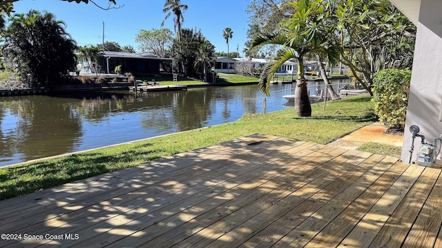 wooden terrace with a lawn and a water view