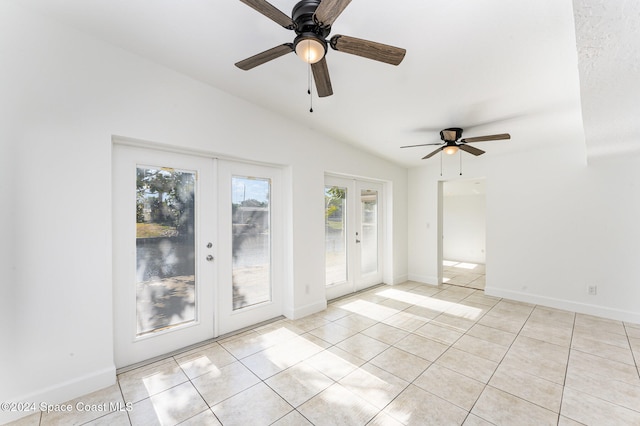 spare room featuring french doors, light tile patterned floors, vaulted ceiling, and ceiling fan